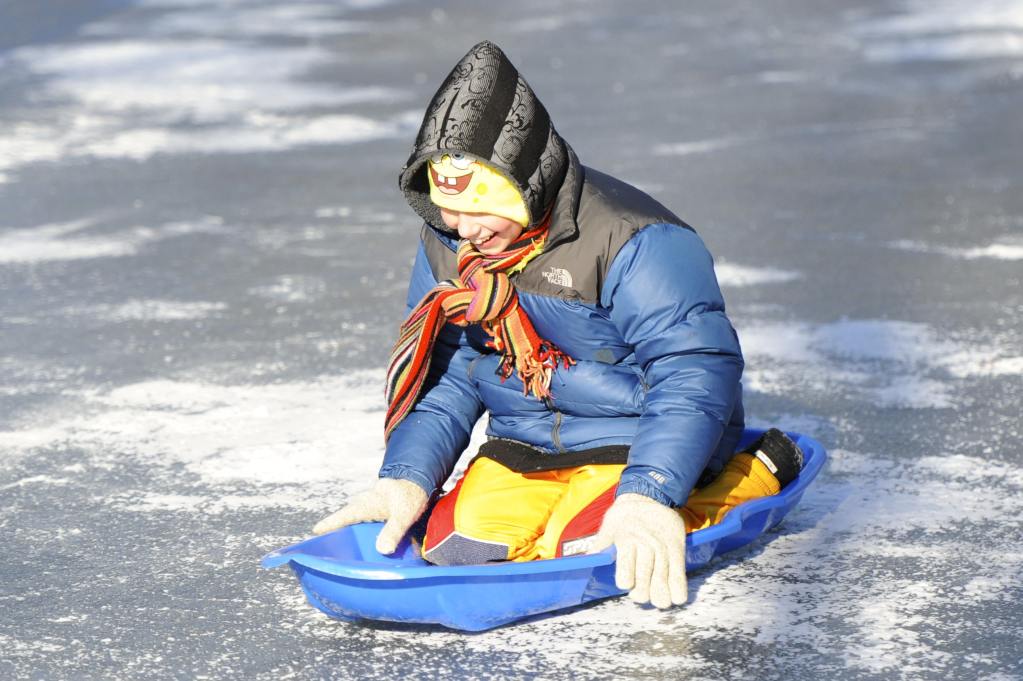 A Glenview New Church School student sledding across the baseball field