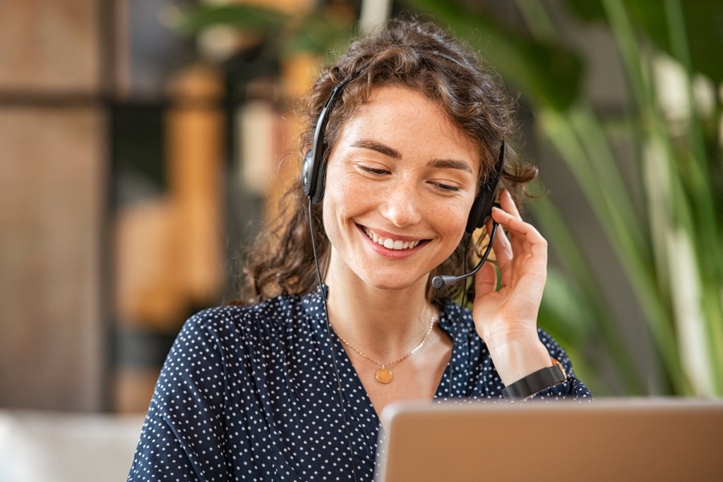 Smiling woman talking to A Glenview New Church Parent on headphones